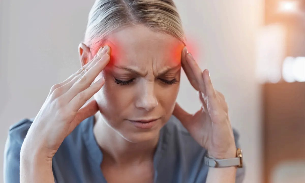 Woman experiencing migraine pain holding her temples