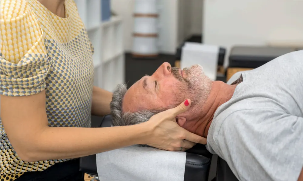 Osteopath performing cranial-sacral therapy for migraine relief
