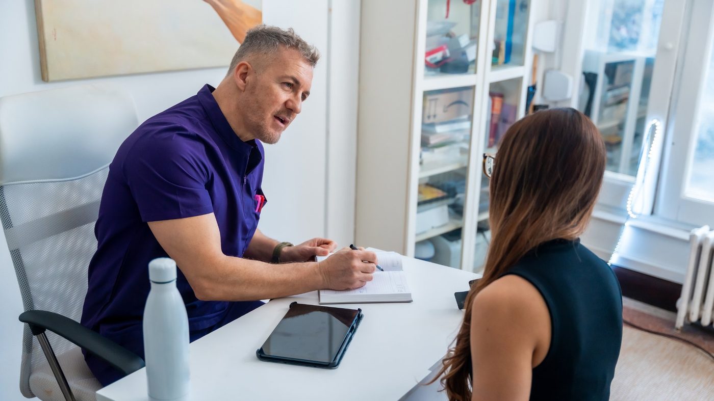 Osteopath consulting with a patient about her sports injury and recovery plan